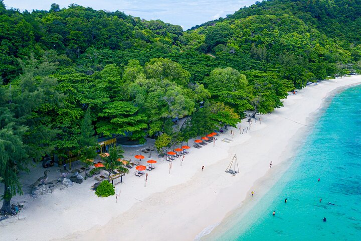 White sand shoreline and green hillside on Coral Island