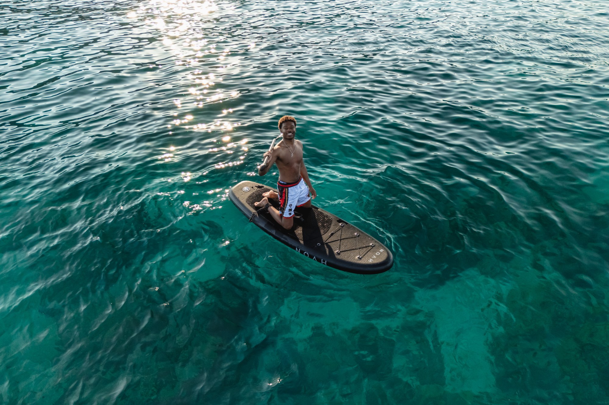 Paddle activity in the clear waters beside Noah Yacht